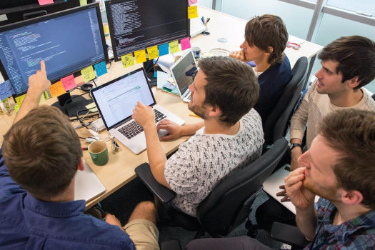 تصویری از یک تیم برنامه نویسی در حال کار روی پروژه در بخش تیم برنامه نویسی چیست در مطلب تشکیل تیم برنامه نویسی