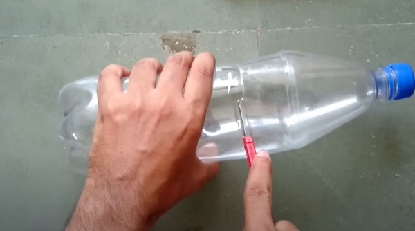 برش یک بطری آب معدنی از وسط با یک کاتر