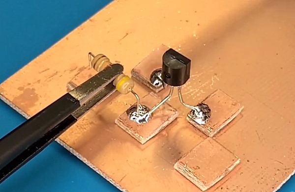 یک ترانزیستور و یک مقاومت روی صفحه طلایی