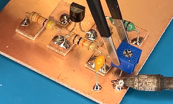 یک ترانزیستور و دو مقاومت و یک سلف و یک خازن روی صفحه طلایی یا برد
