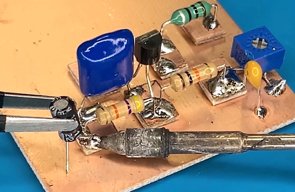 یک ترانزیستور و دو مقاومت و یک سلف و چند خازن روی صفحه طلایی یا برد