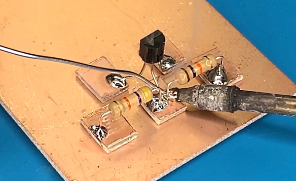 یک ترانزیستور و دو مقاومت روی صفحه طلایی