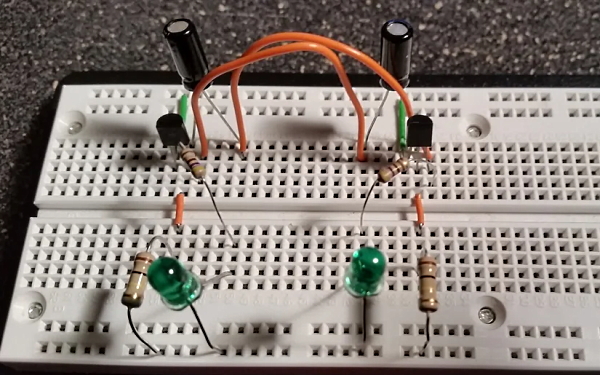 تصویری از یک مدار شامل LED و خازن و ترانزیستور و مقاومت