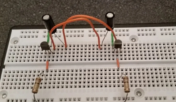 دو خازن، ترانزیستور و مقاومت روی یک برد الکترونیکی نصب شده‌اند.