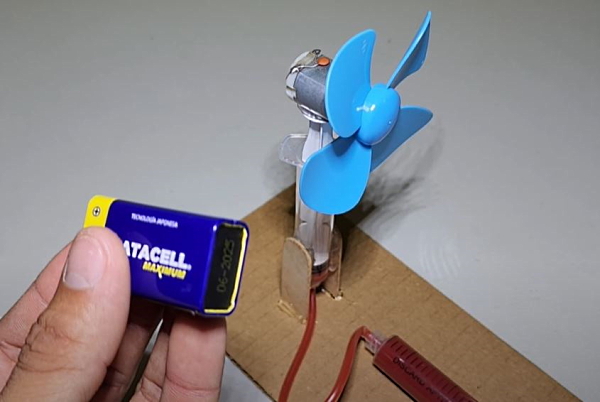 یک پنکه آبی همراه با باتری و سرنگ