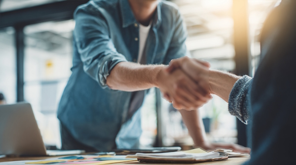 دو همکار در حال دست دادن به هم - واحد برنامه ریزی و بودجه ریزی