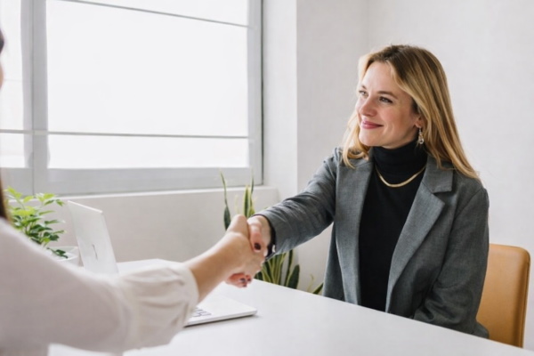 بانویی در حال دست دادن در اتاق مصاحبه