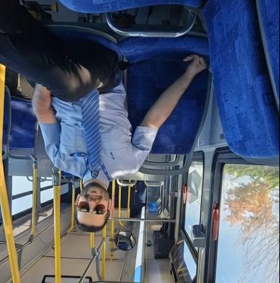 قرینه بالا به پایین از مرد نشسته در اتوبوس