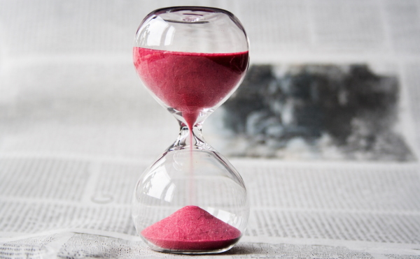 تصویر ساعت شنی با شنهای قرمز داخلش